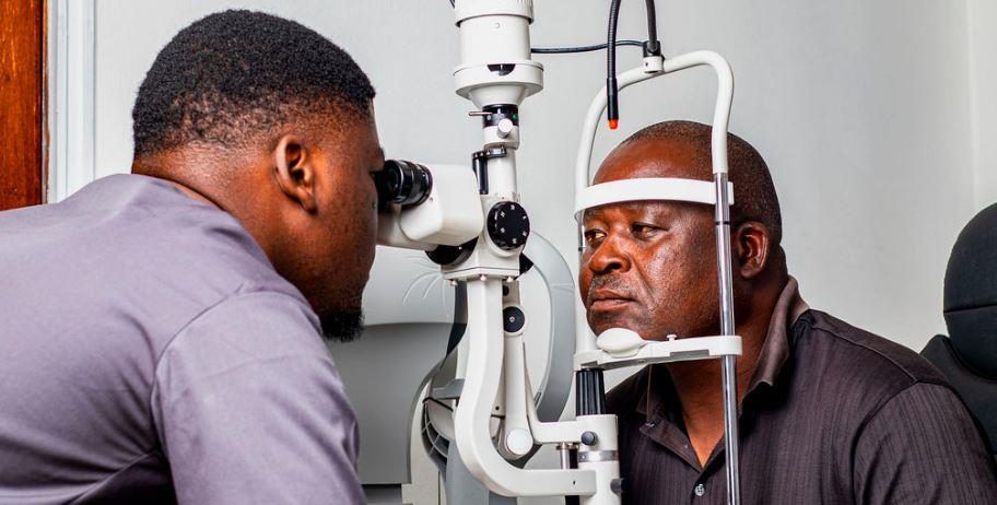 A Clearoptics optometrist conducting an eye examination on a patient using a slit lamp.